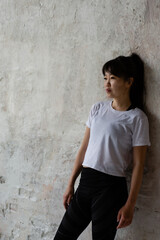 cute Asian girl with dark long hair is standing at the crafting wall 