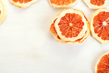Dried slices of red citrus on a white background with copy space