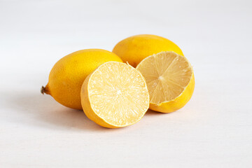 Juicy fresh lemons on a white table. Lemon cut in half