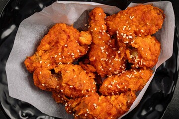 Closeup on crispy fried chicken wings with sesame seeds