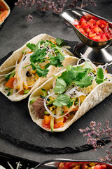 Closeup on tacos filled with beef meat and vegetables