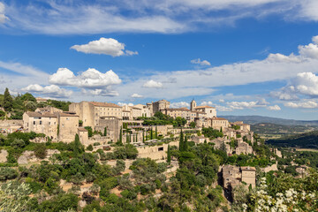 Fototapeta na wymiar Green calcareous rock and antique tiny village of same name Gordes on prominent point over Luberon valley. Vaucluse, Provence, Alpes, Cote d'Azur, France