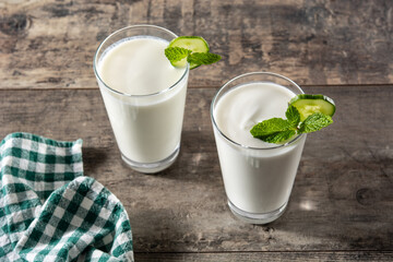 Ayran drink with mint and cucumber in glass on wooden table