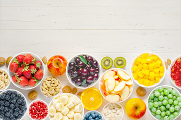 Berries, fruits and nuts on a white wooden background. Vegetarian food. Copy space