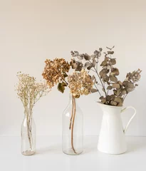  Cllose up of dried flowers in vases on white table including hydrangeas and eucalyptus leaves (selective focus) © Natalie Board