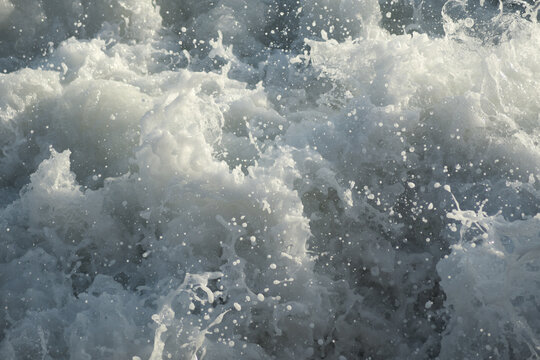 White foan in rough waves sea at sunset