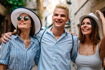 Happy group of young friends enjoying sightseeing tour in the city on summer vacation.