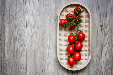 Draufsicht auf frische Rispen Tomaten auf einem Holz Serviertabeltt. Rustikale Stil, Gemüse.