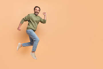 Fototapeta na wymiar Full size portrait of crazy satisfied person rush fast empty space isolated on beige color background