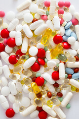 Kolorowe lekarstwa i witaminy w tabletkach rozsypane na białym tle, suplementacja diety, leczenie przewlekłe, farmacja