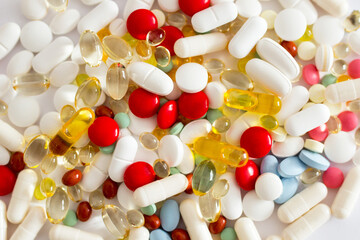 Kolorowe lekarstwa i witaminy w tabletkach rozsypane na białym tle, suplementacja diety, leczenie przewlekłe, farmacja - obrazy, fototapety, plakaty