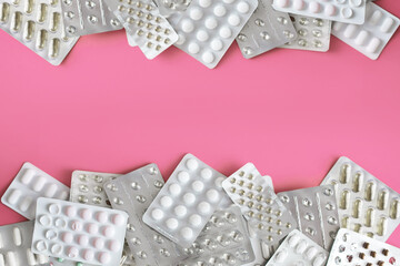 Fototapeta Blistry z lekarstwami i witaminami na różowym tle, leczenie nowotworów, rak piersi, amazonki obraz