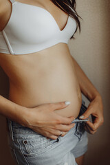Early pregnancy girl in shorts with small belly