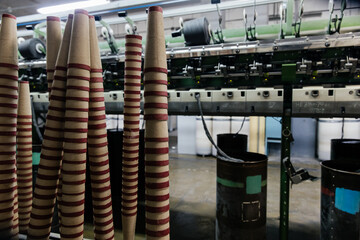 Empty coils stacked in a pyramid in a production room.