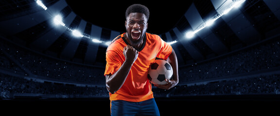 Victory. Excited professional soccer, football player in football kit standing with ball and...
