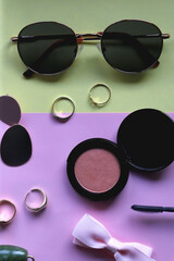 Various accessories, make up products and jewelry on various colorful pastel backgrounds. Flat lay.