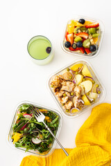 Home cooked food in lunch boxes for office, healthy eating at work and office food, new potatoes with chicken breast, salad and sliced fruits and berries, top view