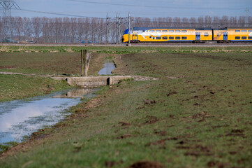 NS Intercity Train Through A Farmfield At Abcoude The Netherlands 15-3-2022 - obrazy, fototapety, plakaty