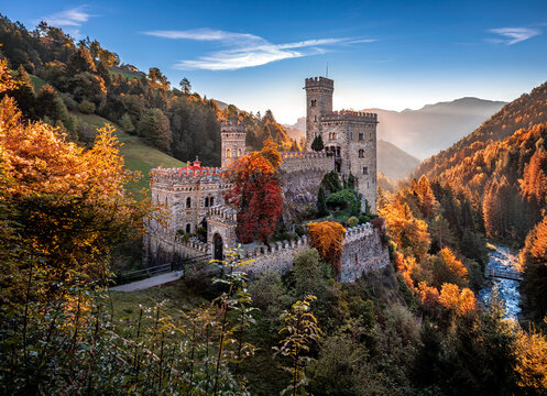Latzfons, Italy - Beautiful autumn scenery at Gernstein Castle (Castello di Gernstein, Schloss Gernstein) at sunrise in South Tyrol with blue sky and golden foliage