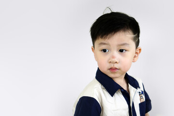 Close up shot of Little child with stylish hairstyle on white background. Little boy. Portrait of a happy little boy looking out.