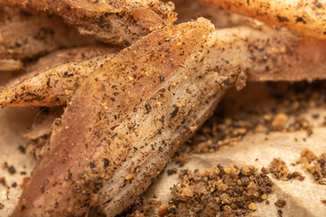 thinly sliced homemade lard with pepper on white oiled paper, close-up, selective focus.