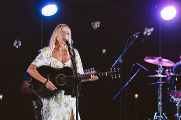 Singer playing guitar on stage