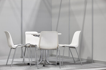 White chairs and table indoor set. Contemporary plastic furniture. Nobody