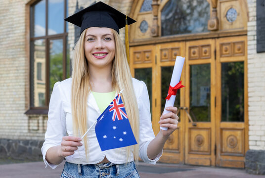 Female Graduate With A Diploma And An Australian Flag Near The University.