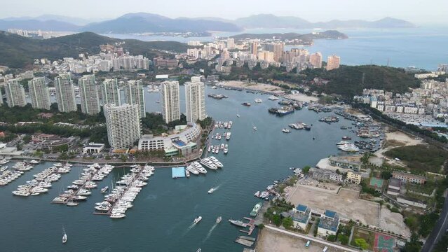 Aerial fly over drone cityscape footage of Sanya city with marina and buildings on Hainan tropical island China