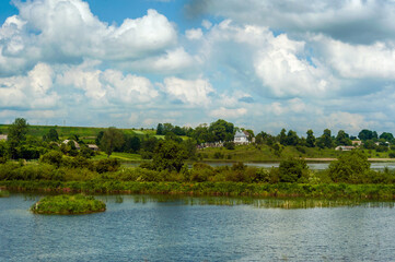 pond with reeds and a beautiful view of the village and the church, rural landscape