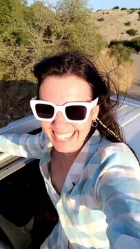 happy woman stick out of car sunroof road trip concept