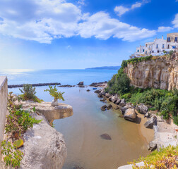 Gargano coast: bay of Vieste in Apulia, Italy. Walking on the shore of the old town beach.