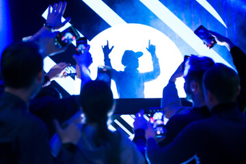 Dj party at nightclub. Crowd rave at the stage background.
