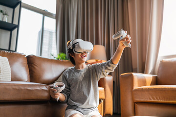 exiting asian child male boy enjoy metaverse gaming with wearable vr headset with control handle...