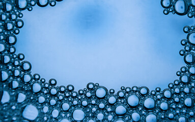 Soap bubbles of blue color in water.