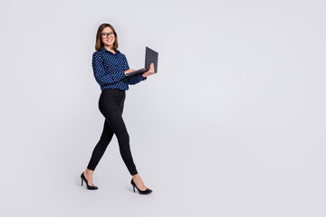 Full body profile portrait of pretty positive girl hold wireless netbook walking isolated on white color background © deagreez