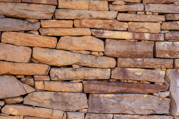 The texture of ancient historical masonry wall made of different sizes of stones without the use of cement.