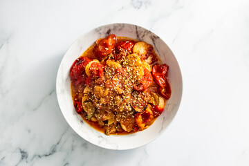 vegan roast with potatoes zucchini and tomatoes topped with sesame seeds, healthy plant-based food