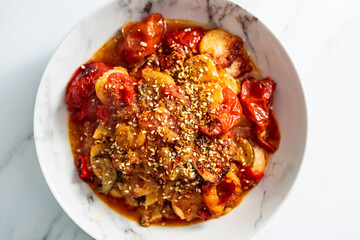 vegan roast with potatoes zucchini and tomatoes topped with sesame seeds, healthy plant-based food