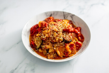 vegan roast with potatoes zucchini and tomatoes topped with sesame seeds, healthy plant-based food