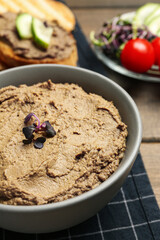 Bowl with delicious liver pate on wooden table, closeup