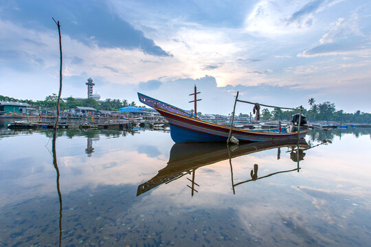 Kolae fishing boats dock on the Bang Nara River at dusk.