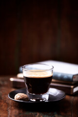 Coffee in glass cup on rustic wooden background. Copy space.
