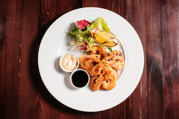 Shrimps with sauce and fried lemon. Fine dinning menu.