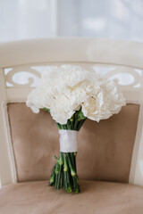 Beautiful big wedding bouquet with white flowers on chair on wedding day