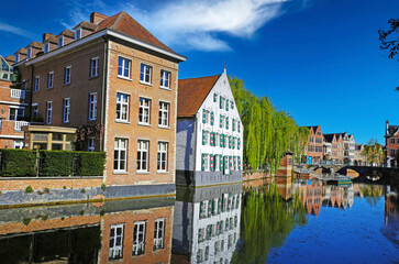 Fototapeta na wymiar Lier, Belgium - April 9. 2022: View over water town moat on medieval romantic old cityscape, ancient stone bridge, clear blue sky