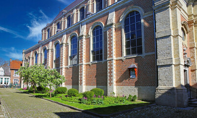 Fototapeta na wymiar Lier (Begijnhof), Belgium - April 9. 2022: View on old church in medieval unesco world heritage site village on sunny day