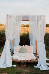 Beautiful wooden bed with white bed and canopy in nature in the village