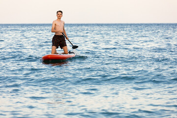 Teen boy paddling on a SUP board