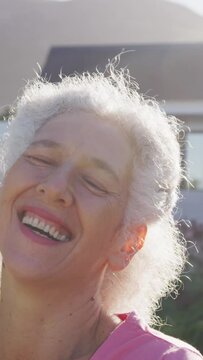 Portrait of happy senior biracial woman in garden on sunny day at retirement home